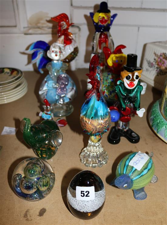 A collection of glass clowns and paperweights